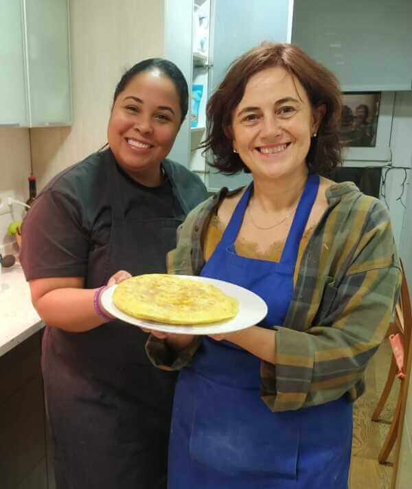 a student and her teacher presenting their homemade spanish tortilla